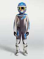 Alpinestars jeugd Fluid Drag gear set, grijze en blauwe motocross-uitrusting inclusief helm en motorlaarzen voor kinderen.