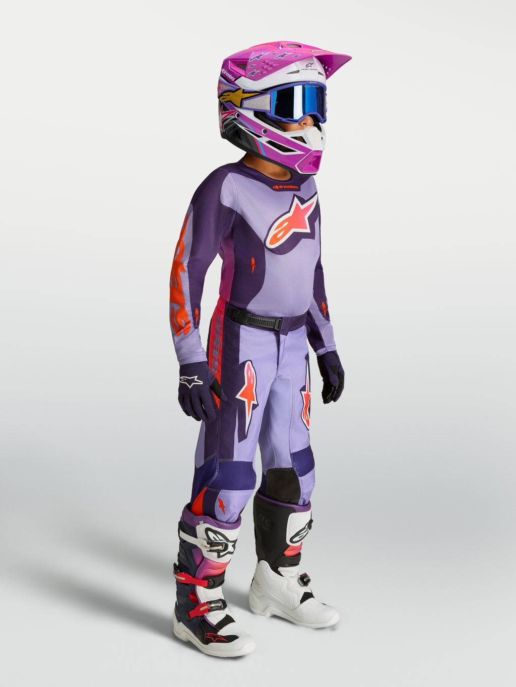 Alpinestars jeugd Fluid Hunt gear set 2027, paars en roze fluo motocrossjersey en -broek voor off-road racing op model.