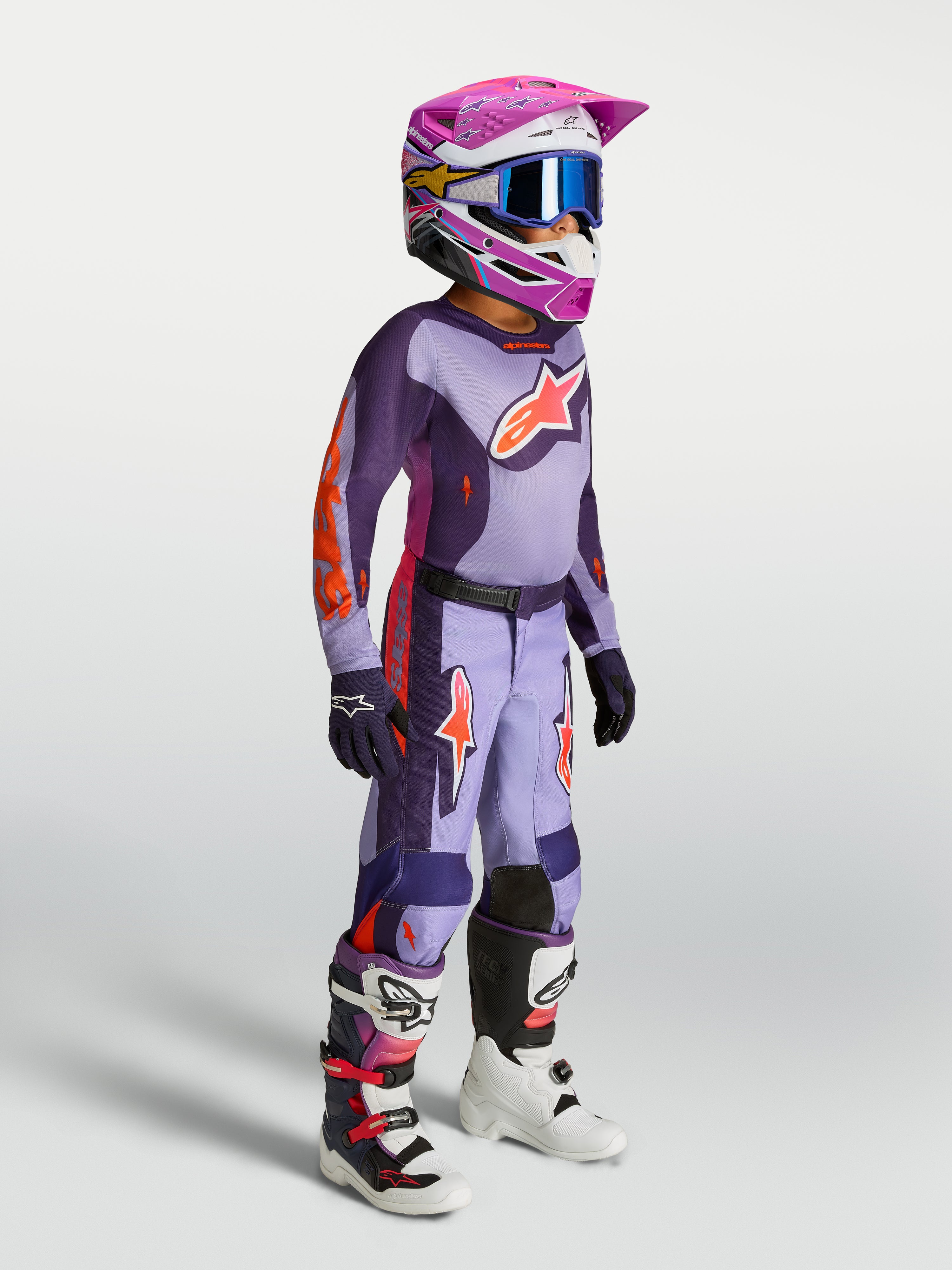 Alpinestars jeugd Fluid Hunt gear set 2027, paars en roze fluo motocrossjersey en -broek voor off-road racing op model.