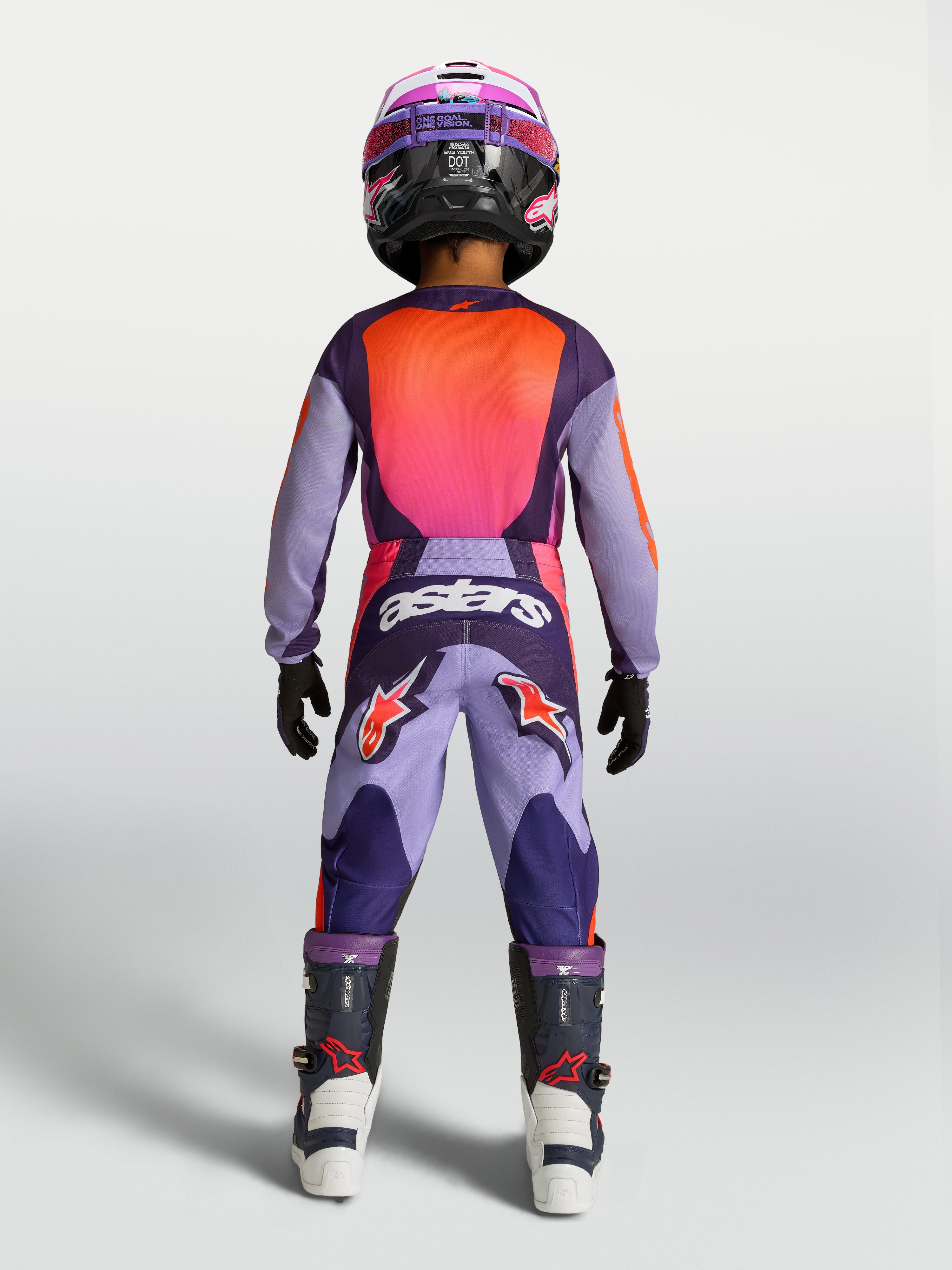 Alpinestars Jeugd Fluid Hunt jersey 2027 en gear set, paarse en roze motocross-outfit, achteraanzicht van rijder.