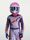 Alpinestars Jeugd Fluid Hunt Jersey 2027, paarse en roze fluo motorcrossjersey gedragen met helm en veiligheidsbril.