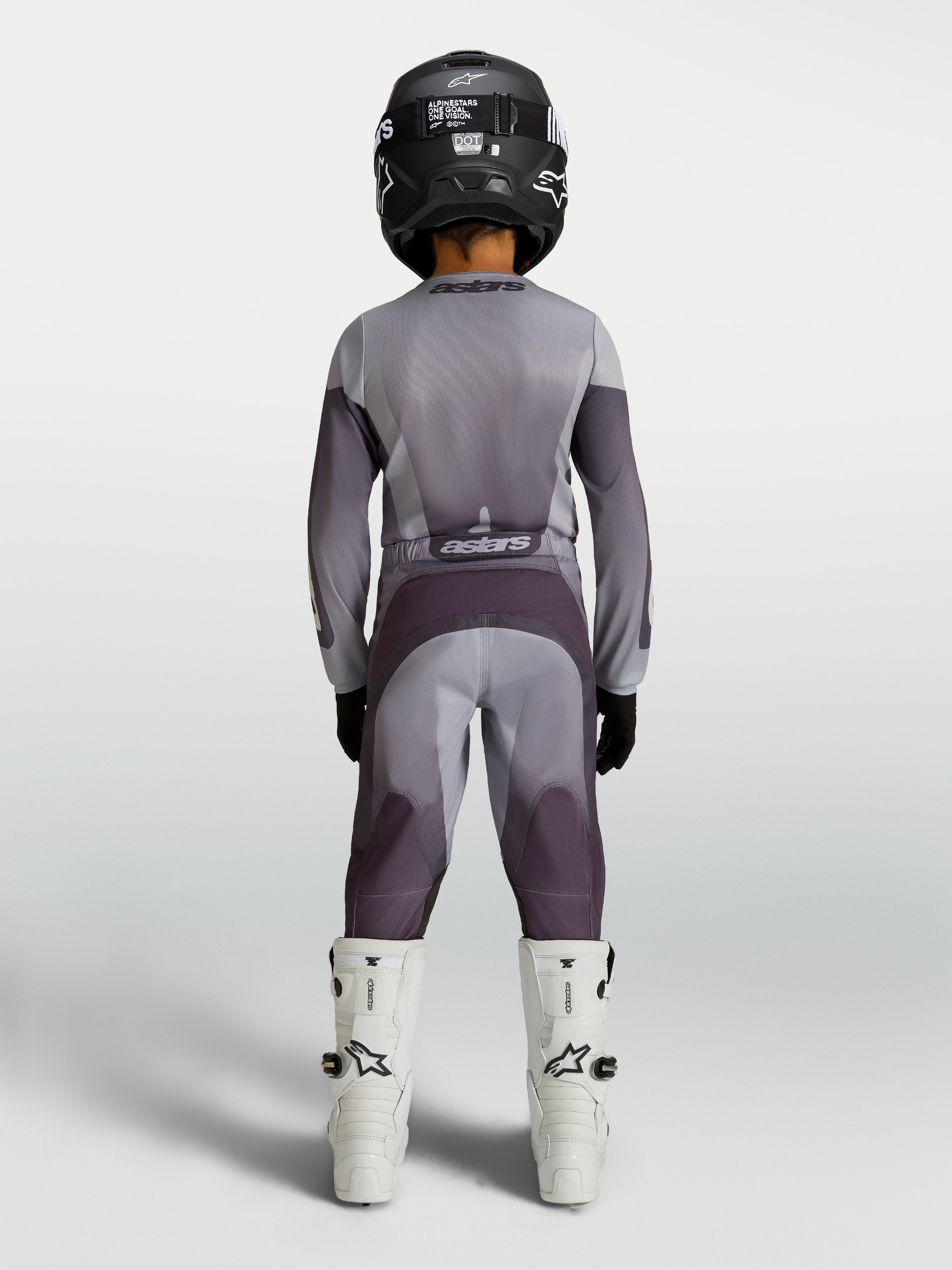 Alpinestars 2027 Jeugd Fluid Amber Jersey en Gear Set, grijze en paarse motocrossuitrusting, achteraanzicht op jeugdrijder.