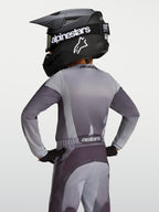 Alpinestars Jeugd Fluid Amber Jersey 2027, grijze en zandkleurige motocrossjersey, vochtafvoerende stof, achteraanzicht jonge rijder.