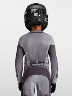 Alpinestars Jeugd Fluid Amber Jersey, motorcrossjersey voor kinderen, zand en grijs, achteraanzicht van een jonge rijder.
