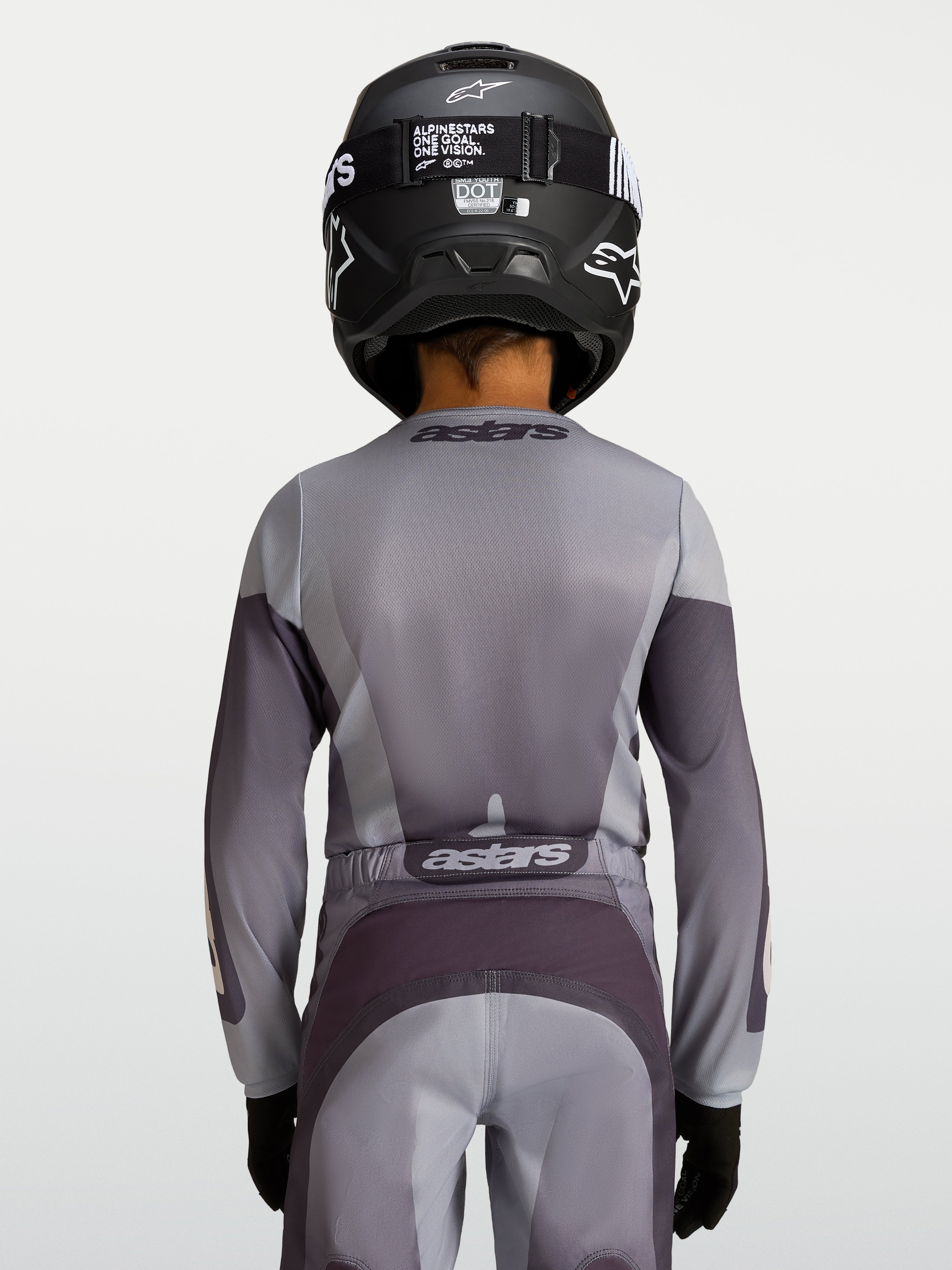 Alpinestars Jeugd Fluid Amber Jersey, motorcrossjersey voor kinderen, zand en grijs, achteraanzicht van een jonge rijder.