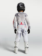 Alpinestars Jeugd Fluid Lone jersey en gear set 2027, motorcrosskleding voor kinderen, grijs camouflage en wit met rode accenten, achteraanzicht.