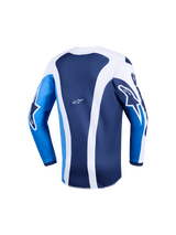Alpinestars 2026 Youth Fluid Portl Jersey, jeugd motocross jersey, Ucla Blue en wit, achteraanzicht met verticale witte strepen op een donkerblauwe basis, helderblauwe mouwen met witte logo's, verlengde achterzoom voor extra bedekking, lichtgewicht prestatiegerichte uitrusting voor jonge rijders