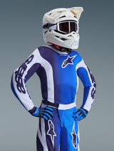 Alpinestars 2026 Youth Fluid Portl Jersey, jeugd motorcross shirt, UCLA blauw en wit, met een kleurgeblokt ontwerp en ster-logo, gedragen met bijpassende broek, handschoenen en een witte helm met bril, gecoördineerde race-uitrusting voor jongeren