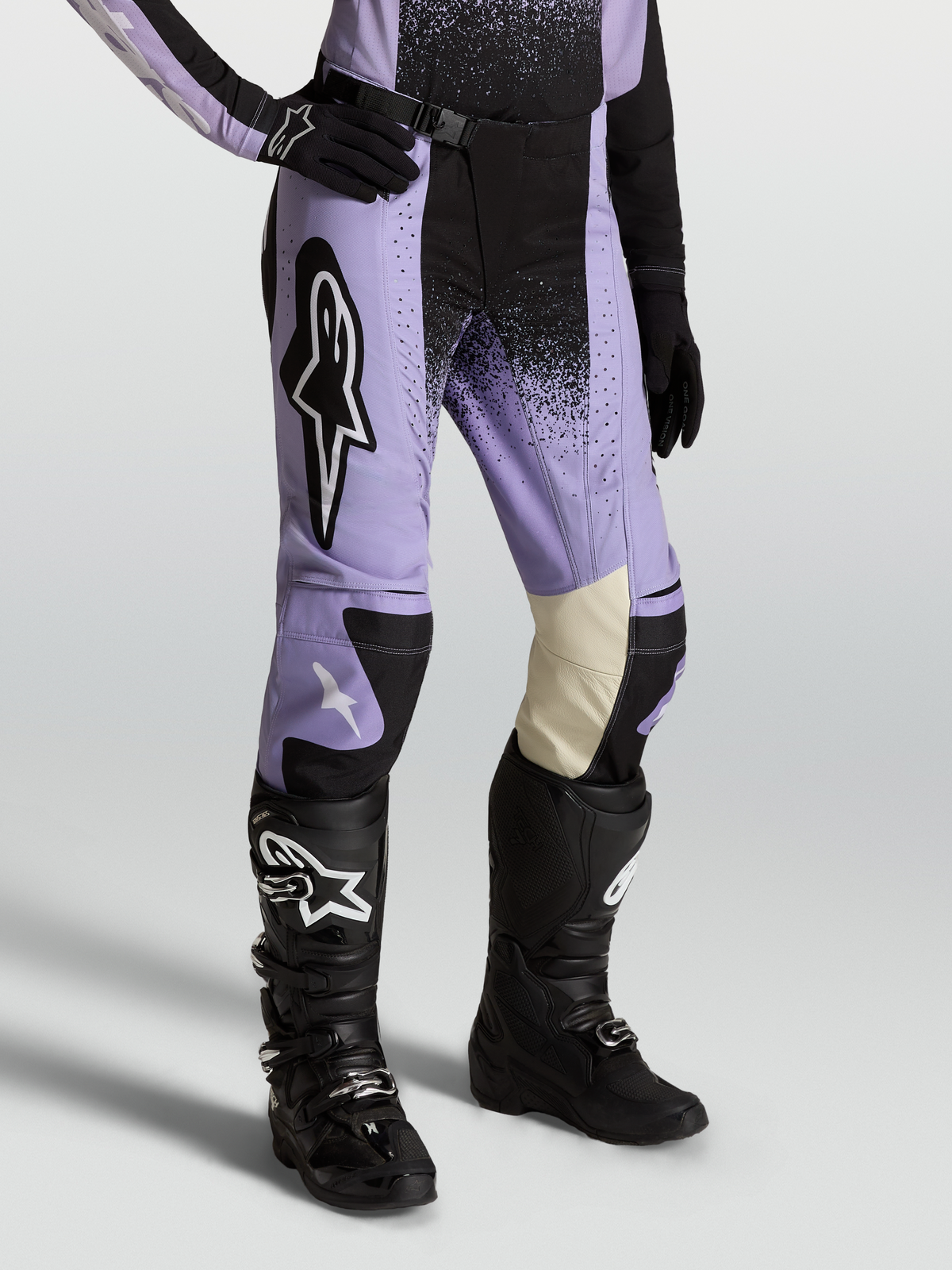 Alpinestars Stella Techstar Swan Broek, dames-motocrossbroek in paars en zwart, lederen binnenknieën, gedragen met Tech 7 laarzen.