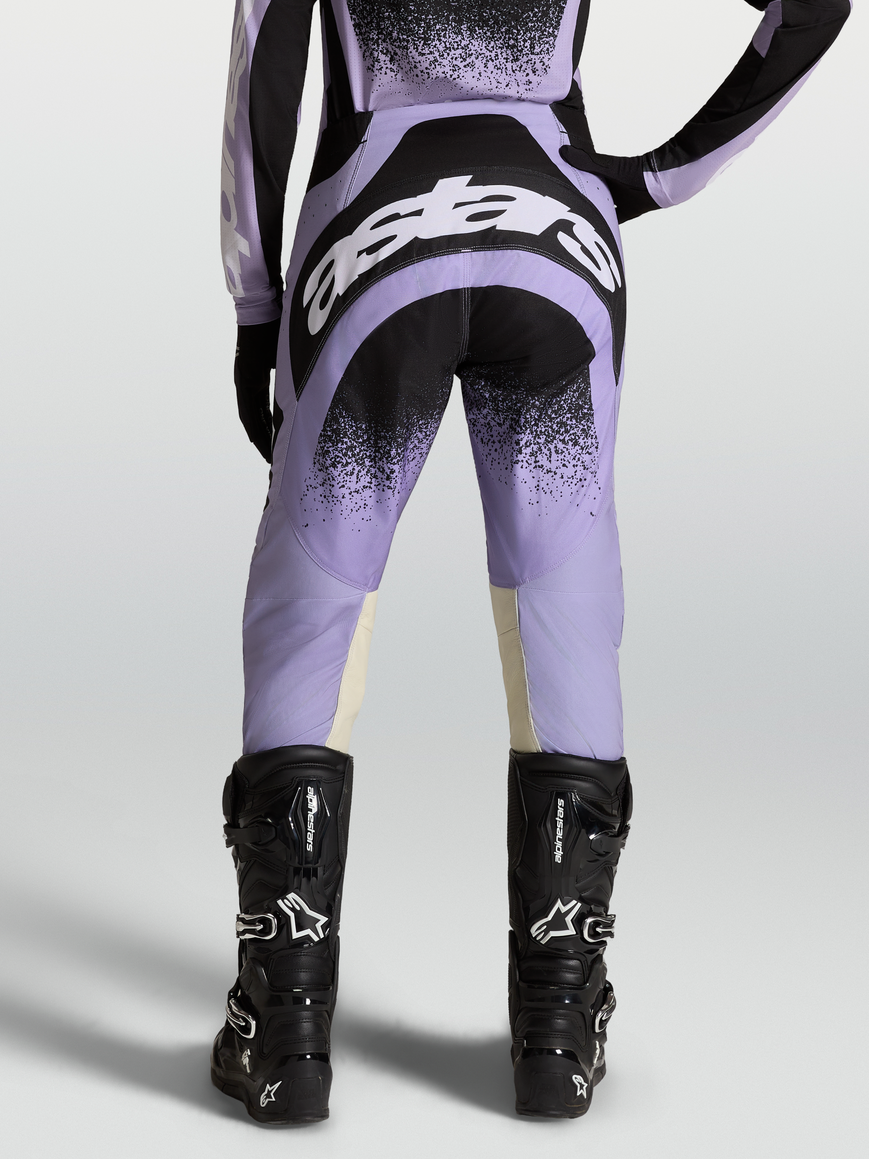 Alpinestars Stella Techstar Swan Pants, women's motocross gear in purple and black with white logos, worn on-model with black boots.