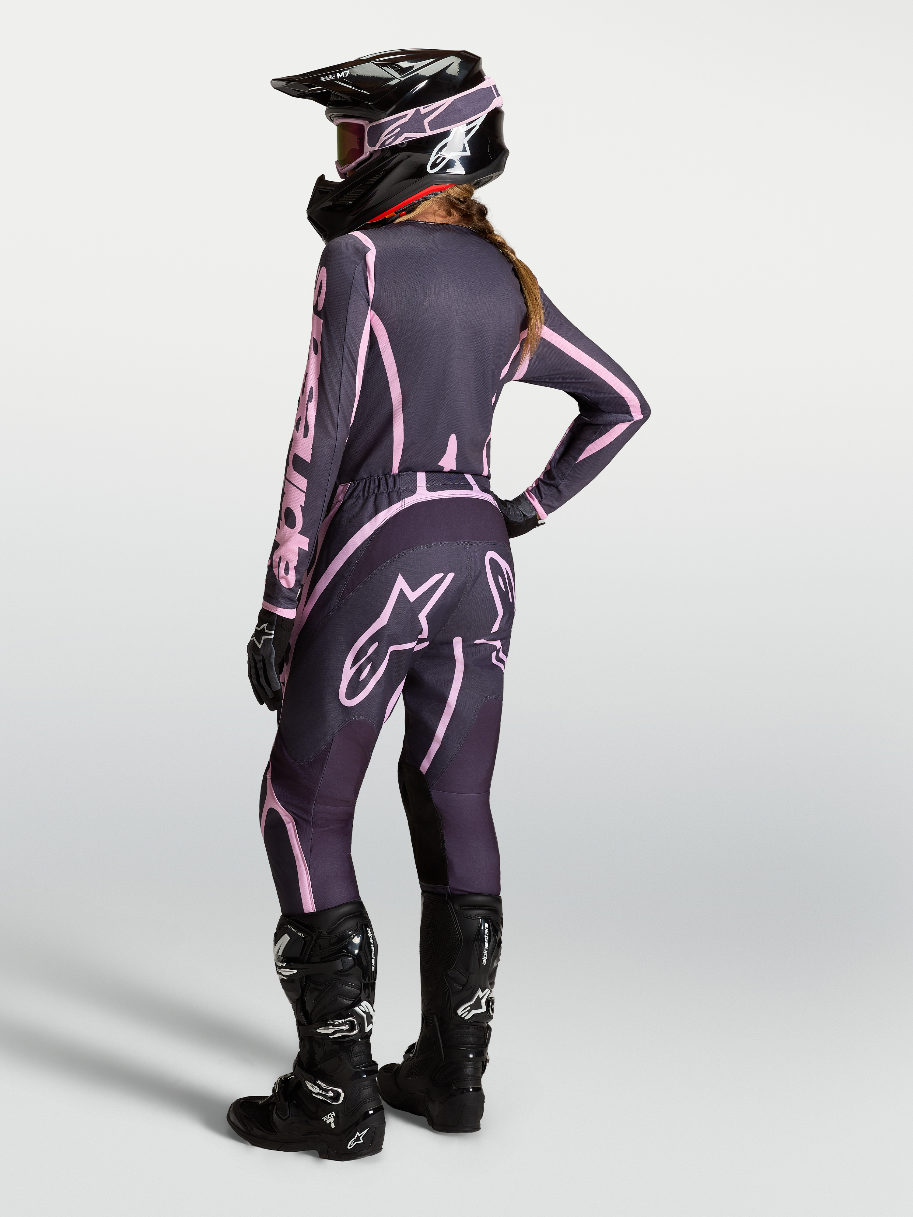 Alpinestars Stella Fluid Apex V2 dames motorcrossbroek in grijs en roze, complete off-road outfit van achteren gezien.