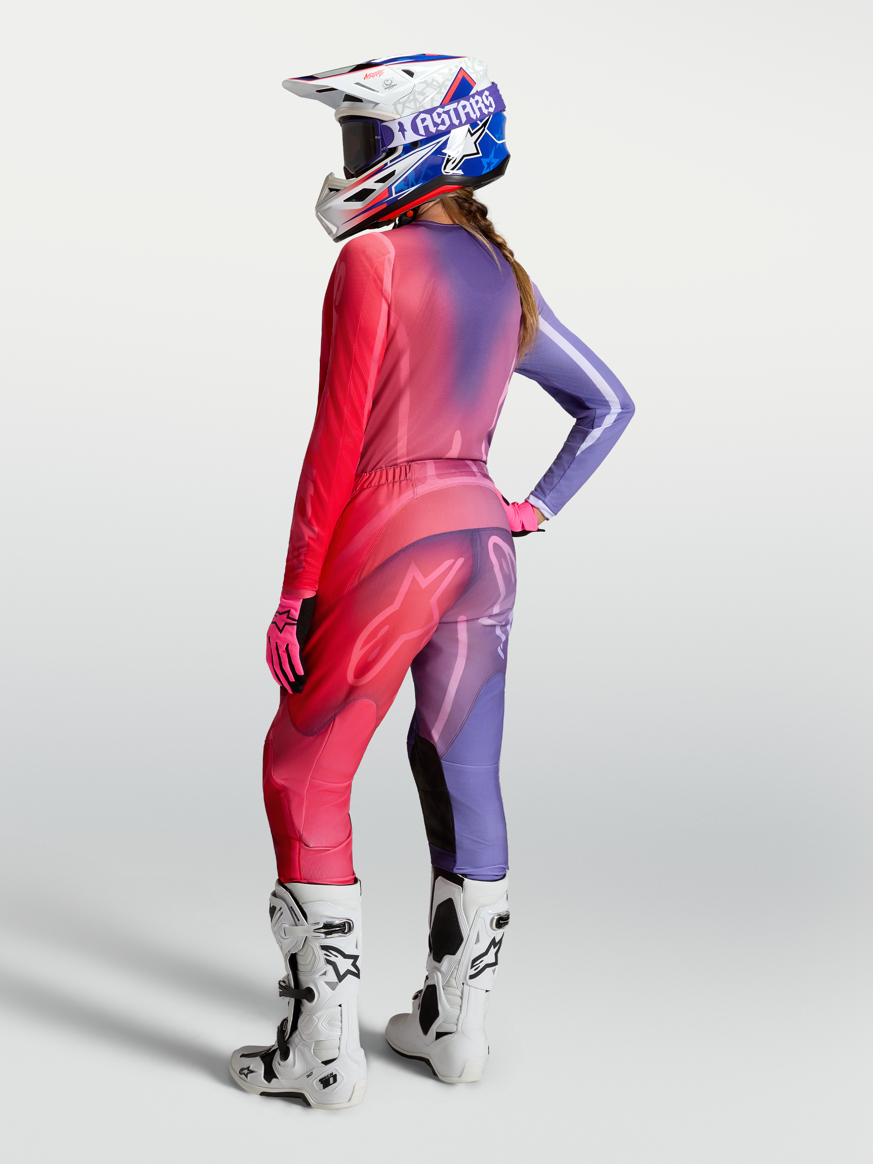 Alpinestars Stella Fluid Kepler jersey, dames-motorcrossjersey, paars en rood, met bijpassende broek en witte motorlaarzen.