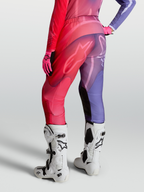 Alpinestars Stella Fluid Kepler broek, dames motocrossbroek in paars en rood, voorgevormde pijpen en stretchpanelen, gedragen met witte Tech 10 laarzen.