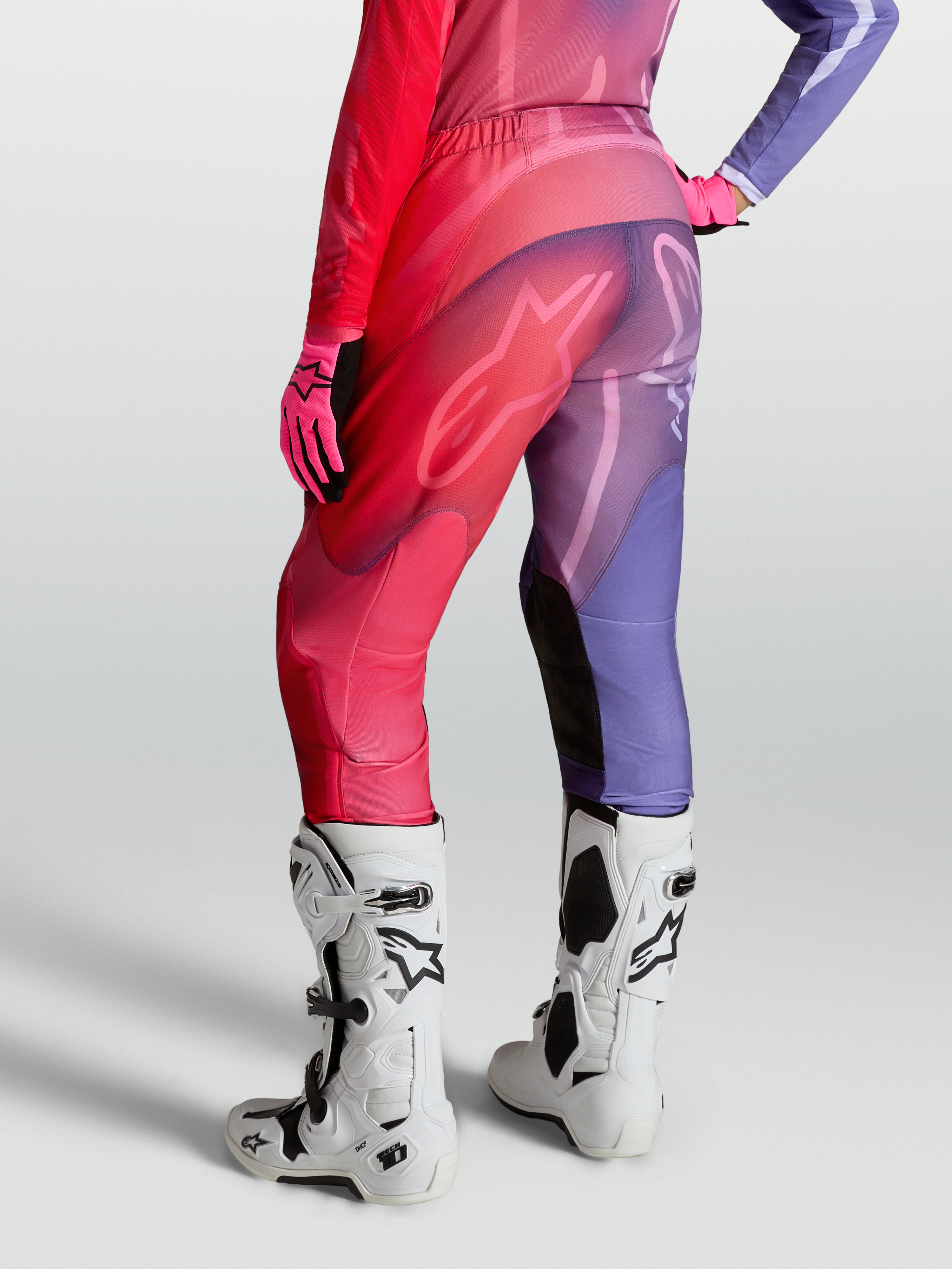 Alpinestars Stella Fluid Kepler broek, dames motocrossbroek in paars en rood, voorgevormde pijpen en stretchpanelen, gedragen met witte Tech 10 laarzen.