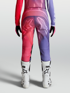 Alpinestars Stella Fluid Kepler Broek, paarse en roodroze dames motorcrossbroek met ergonomische pasvorm en witte MX-laarzen.