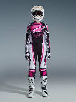 Alpinestars 2026 Stella Techstar Nomur dames gearset, volledige motorcross race-outfit in zwart, wit en fuchsia, jersey met een groot sterlogo en roze spatontwerp, bijpassende broek, witte helm met crossbril, zwart-witte laarzen, gecoördineerde off-road uitrusting voor dames