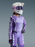 Alpinestars 2026 Woman Stella Fluid Apex Gear Set, Purple and lavender motocross jersey and pants, worn by a rider with a white helmet and purple goggles, featuring bold white Alpinestars branding and logos