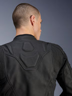 Alpinestars Dusk leren jas, zwart, close-up van de bovenrug en schouders met het DUSK-logo in reliëf op een gewatteerd paneel, lederen accordeon stretch-inzetstukken, premium runderleren constructie