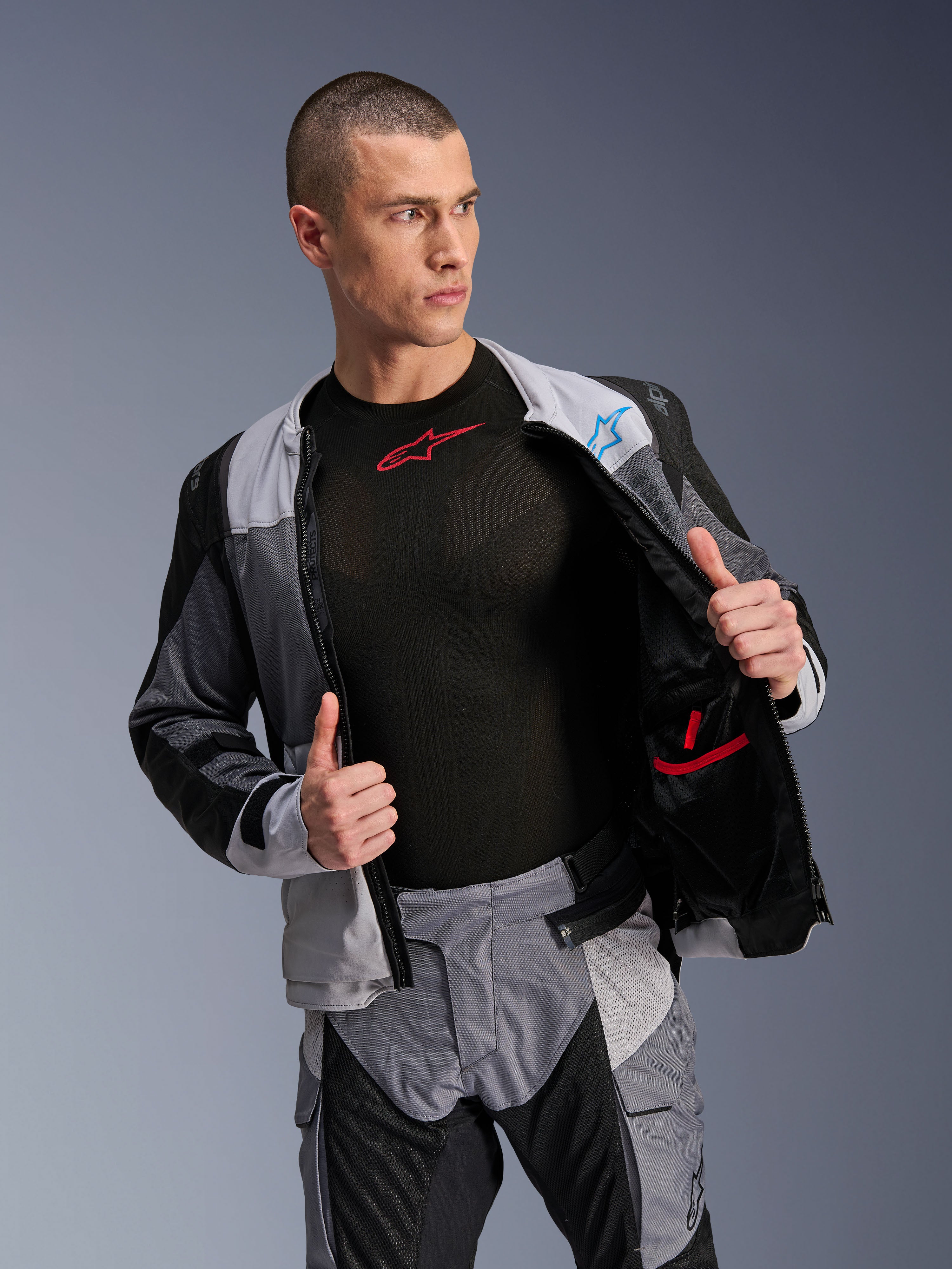 Alpinestars ST-2 Air Jacket, Ice Gray Dark Gray Black, motor toerjas, open gedragen om de mesh binnenvoering en zakken te tonen, gecombineerd met bijpassende broek en zwarte base layer