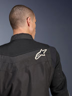 Alpinestars T-Dyno Air Jacket, zwarte textiele motorjas, close-up achteraanzicht met de nadruk op het ademende 3D-mesh op het schouderstuk en de mouwen, voorzien van een wit en zwart sterlogo op de rechterschouder.