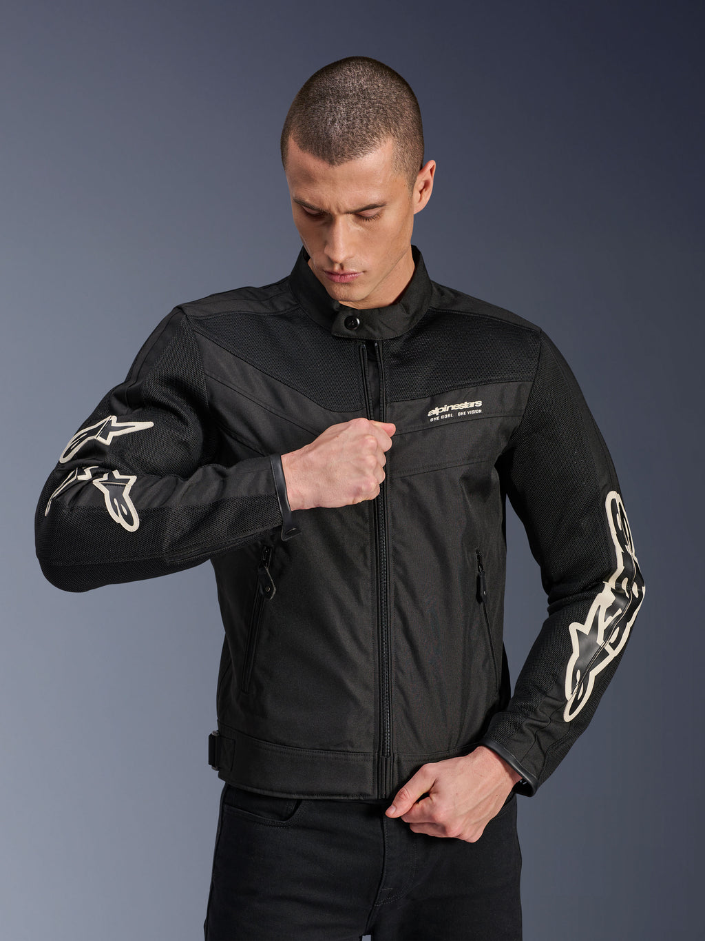 Alpinestars T-Dyno Air Jacket, zwart, textiele motorjas met 3D-meshpanelen en witte logo's op de mouwen, gedragen door een model dat de rits aan de voorkant sluit, urban street riding-stijl