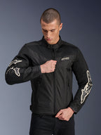 Alpinestars T-Dyno Air Jacket, zwart, textiele motorjas met 3D-meshpanelen en witte logo's op de mouwen, gedragen door een model dat de rits aan de voorkant sluit, urban street riding-stijl