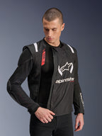 Alpinestars T-Stunt Air jas, zwart-witte motorjas, gedragen door mannelijk model, toont de modulaire mesh-constructie en zichtbare interne protectie op schouder en elleboog, Alpinestars-logo op de borst, Tech-Air Ready, sportieve pasvorm voor rijden op de weg