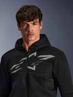 Alpinestars Chrome Superairflow Hoodie, zwarte motorhoodie, voorzien van 3D-meshconstructie met een groot wit grafisch logo op de borst, gedragen door een model, urban sport-rijuitrusting met een modern geventileerd ontwerp