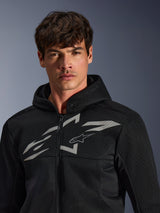 Alpinestars Chrome Superairflow Hoodie, zwarte motorhoodie, voorzien van 3D-meshconstructie met een groot wit grafisch logo op de borst, gedragen door een model, urban sport-rijuitrusting met een modern geventileerd ontwerp