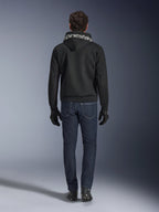 Alpinestars Chrome Superairflow Hoodie, zwarte motorhoodie met witte branding op de capuchon, achteraanzicht, gedragen met een donkerblauwe jeans, zwarte handschoenen en zwart-witte laarzen, urban sportieve motoruitrusting