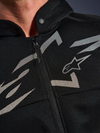 Alpinestars Chrome Superairflow Hoodie, motorhoodie, zwart met witte en grijze graphics, close-up van de borst met 3D technische mesh-constructie, ritssluiting aan de voorzijde en kraag met drukknoop, voorzien van Alpinestars logo