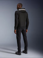 Alpinestars Chrome V2 Sport Hoodie, zwart, achteraanzicht met witte Alpinestars-branding op de capuchon, gedragen met zwarte broek en motorschoenen, casual stedelijke motorkleding met een atletisch silhouet