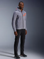 Alpinestars Chrome V2 Sport Hoodie, grijs gemêleerd en fluo rood, gedragen door een mannelijk model met zwarte broek en donkere sportschoenen, met een feloranje sterlogo op de borst en capuchon, casual stedelijke motorkleding
