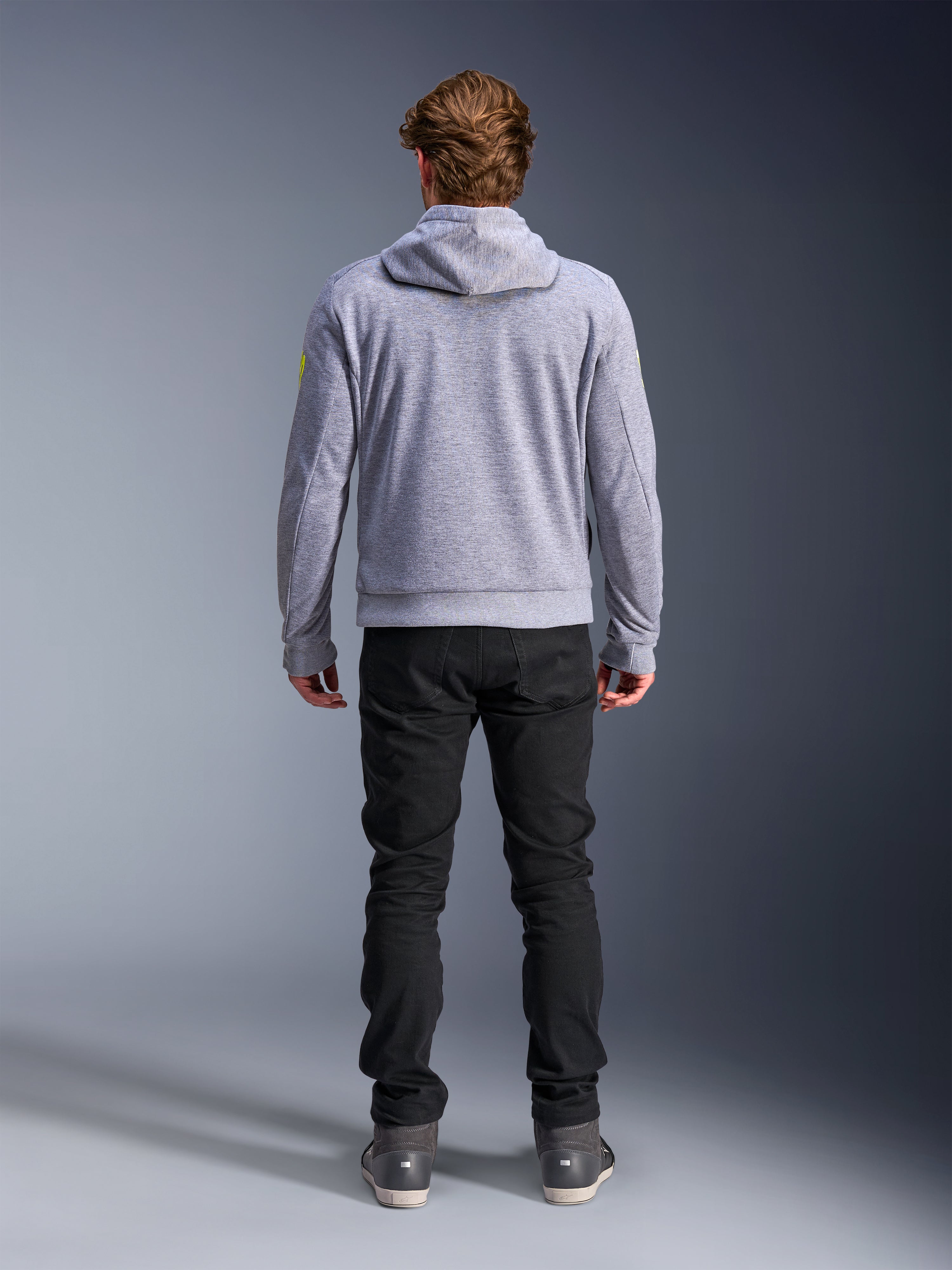 Alpinestars Chrome V2 Sport Hoodie, Gray Heather Fluo Yellow, achteraanzicht van stedelijke motorkleding, tech fleece hoodie gedragen met zwarte broek, voorzien van fluogele accenten op de mouwen