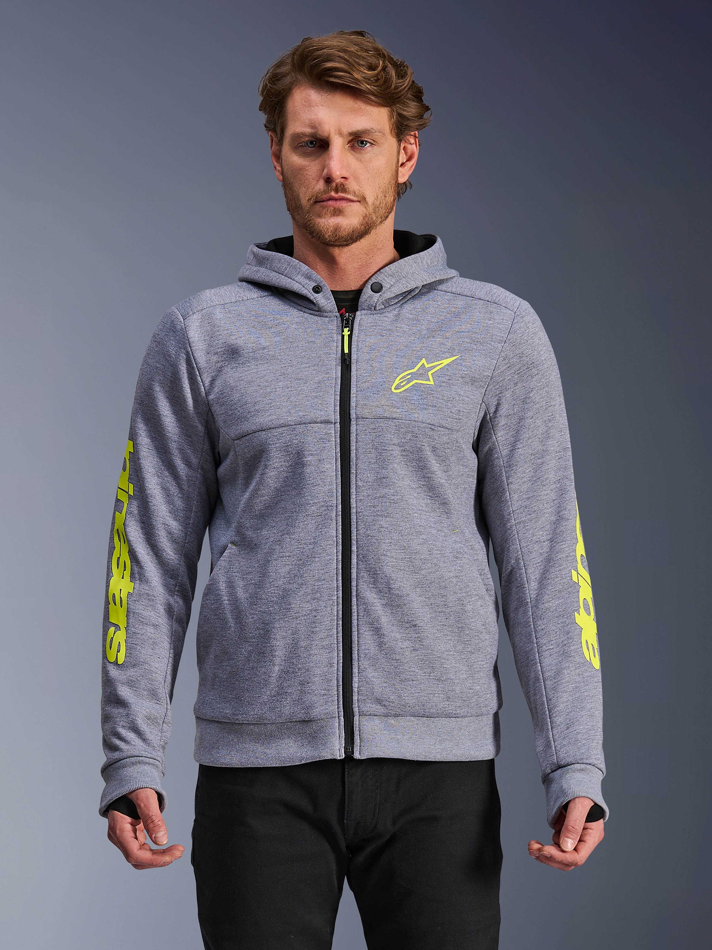 Alpinestars Chrome V2 Sport Hoodie, grijs gemêleerd en fluogeel, motorhoodie met rits voorzien van geel sterlogo op de borst en gele branding op de mouwen, duimlussen en zwarte rits, tech fleece textuur, casual stedelijke motorkleding