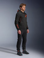 Alpinestars Chrome Air Sport Hoodie, Black Red Fluo, urban motorjas met tech fleece, gedragen met zwarte broek en motorlaarzen, voorzien van mesh ventilatiepanelen en rode fluorescerende logo's op de borst en mouw.