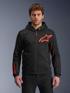 Alpinestars Chrome Air Sport Hoodie, zwarte hoodie met rits met fluo rood sterlogo en accenten op de mouwen, rode mesh zijpanelen voor ventilatie, casual stedelijke motorkleding gedragen door een model