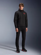 Alpinestars MM93 Radium Tech Hoodie, urban motorjas, zwart met felrode accenten, gedragen door model met zwarte broek en motorschoenen, voorzien van rood '93' logo op de borst en Marc Marquez branding op de mouw, casual technische streetwear voor stedelijk rijden
