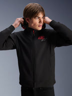Alpinestars MM93 Radium Tech Hoodie, urban motorjas, zwart met rode en zilveren logo's, gedragen door een mannelijk model, voorzien van een volledige ritssluiting en geribbelde manchetten, casual lifestyle motorsportkleding