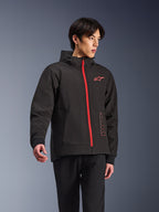 Alpinestars Radium Tech Hoodie, urban motorjas, zwart met felrode rits, rood Alpinestars-logo op de borst en rode tekst op de zijkant, technische winddichte shell met capuchon en geribde manchetten, moderne streetstyle voor motorrijders