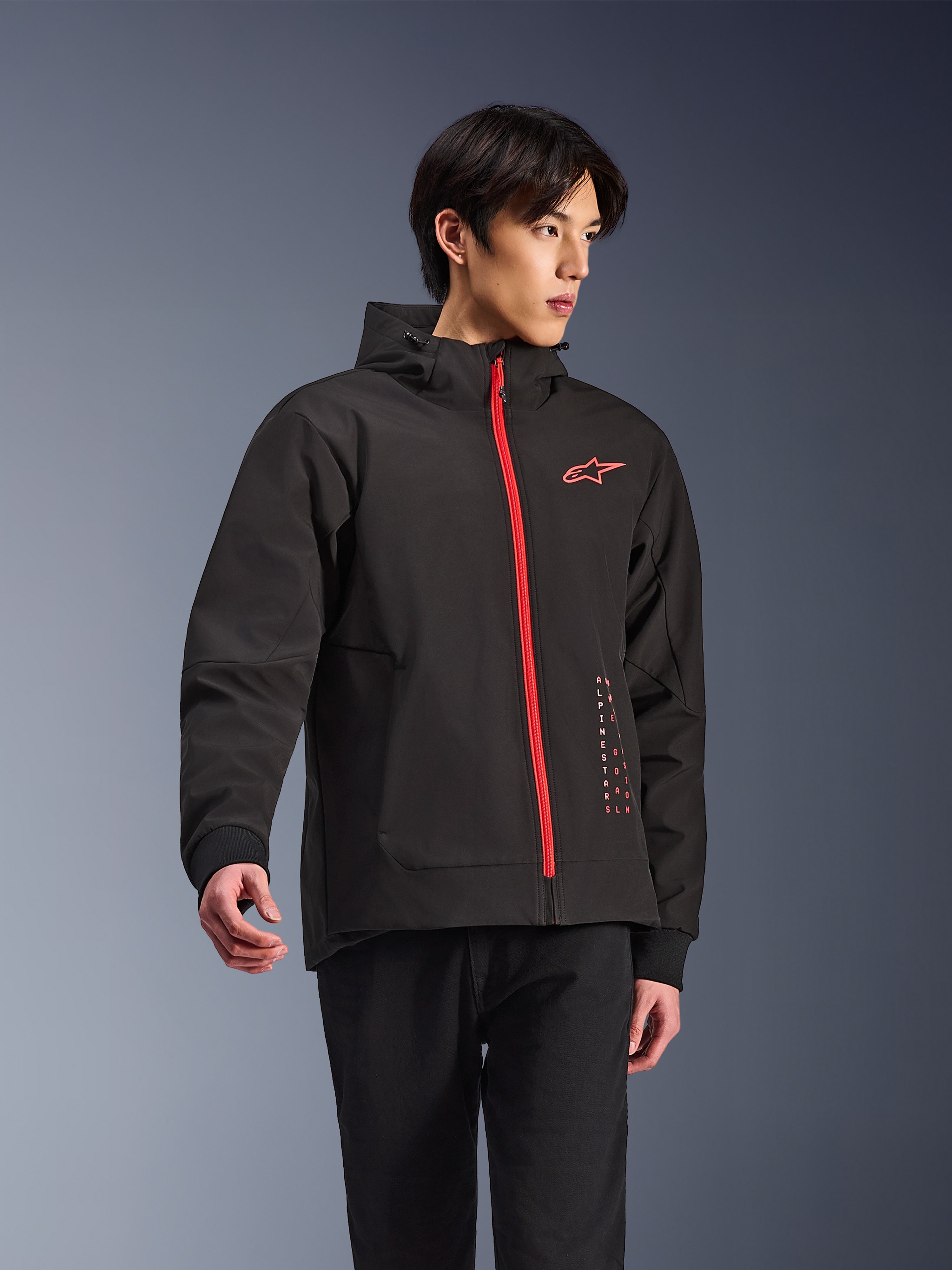 Alpinestars Radium Tech Hoodie, urban motorjas, zwart met felrode rits, rood Alpinestars-logo op de borst en rode tekst op de zijkant, technische winddichte shell met capuchon en geribde manchetten, moderne streetstyle voor motorrijders