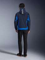 Alpinestars Radium Tech Hoodie, Night Navy en Royal Blue, achteraanzicht met verticale 'ALPINE' branding op de capuchon, royal blue zijpanelen en zoom, casual stedelijke motorhoodie met winddichte 3L shell, gedragen met zwarte broek