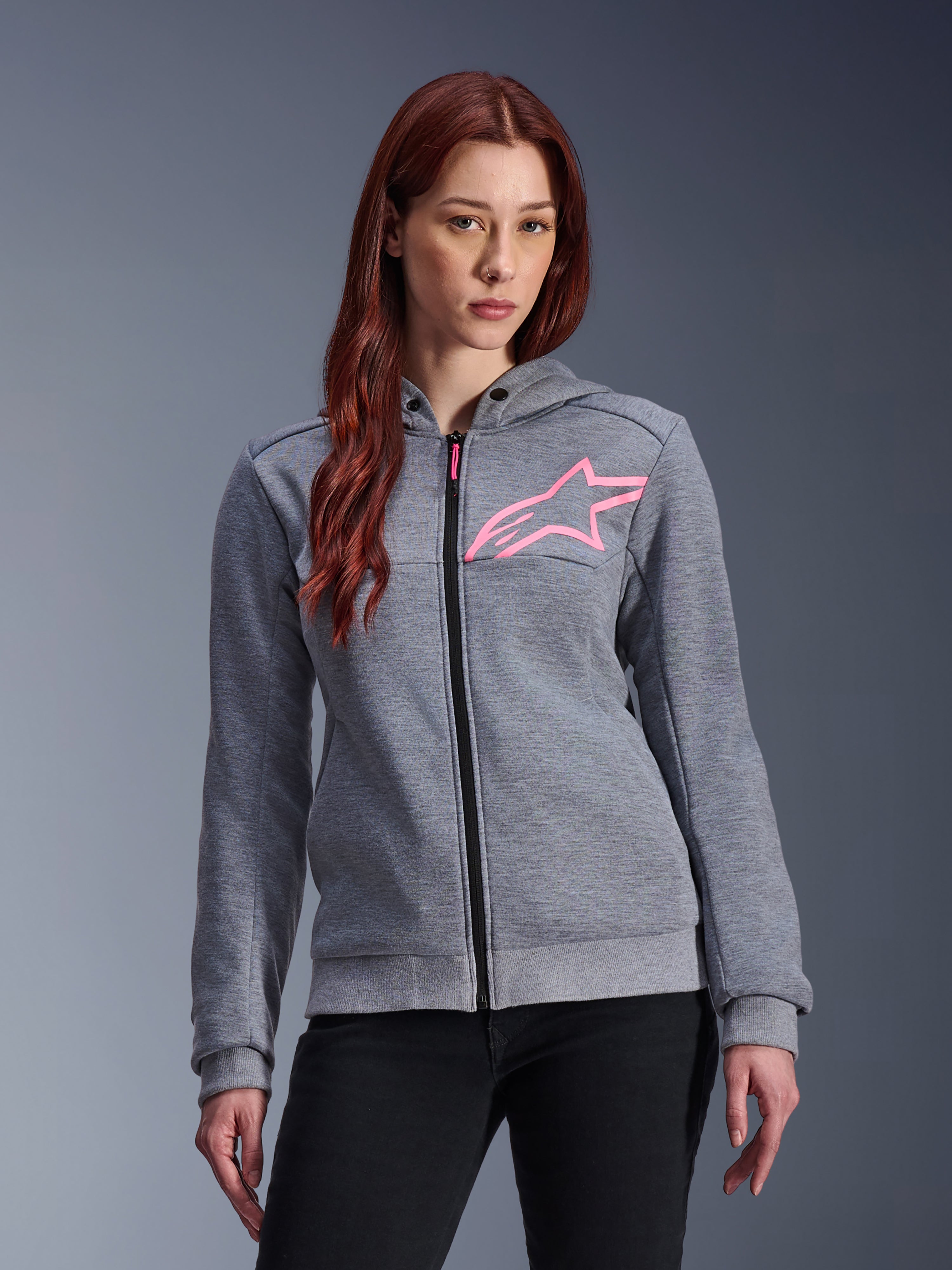Alpinestars Stella Chrome V2 Sport Hoodie, motorhoodie voor dames, grijs gemêleerd met fluoroze sterlogo, tech fleece stof met geribbelde manchetten en zoom, zwarte rits aan de voorzijde met roze trekker, casual urban riding streetwear gedragen met zwarte broek