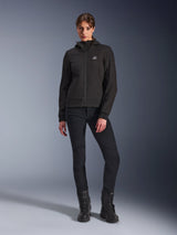 Alpinestars Stella Radium Tech Hoodie in Black, Women's urban motorcycle tech shell, worn with black slim-fit pants and black boots, featuring a small chest logo and hood, lightweight windproof construction for urban riding