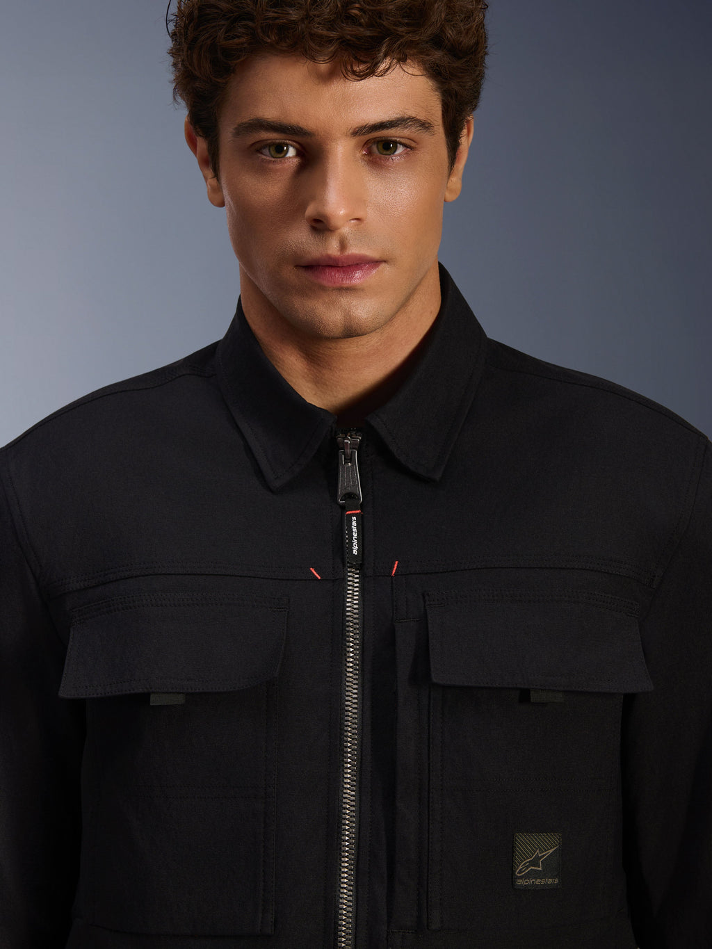 Alpinestars Bryon Water Resistant Overshirt, Black, close-up view of front zipper and chest pockets, durable waxed canvas texture, minimalist urban design with branded accents and woven logo label
