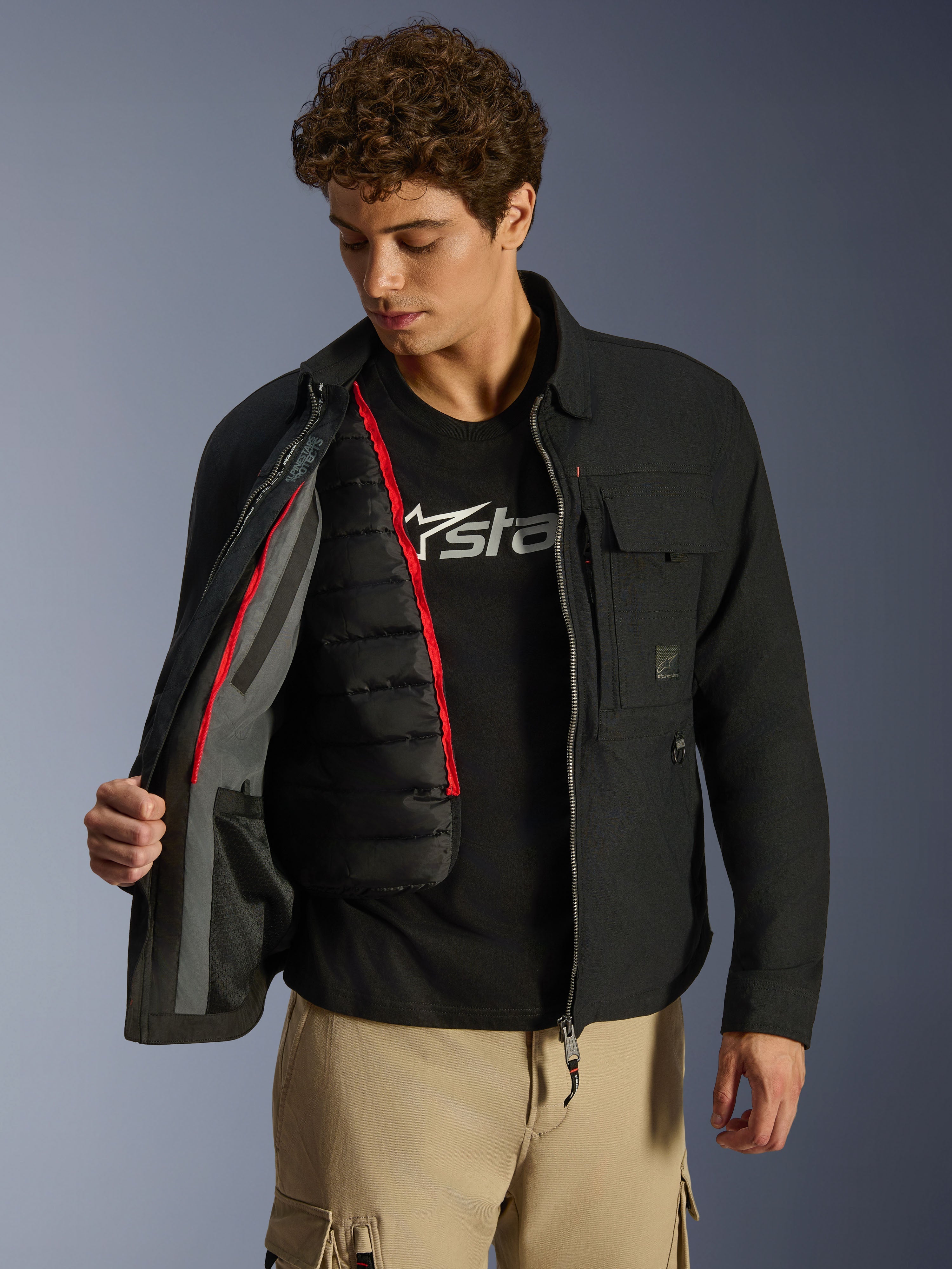 Alpinestars Bryon WR Overshirt, Black, urban motorcycle jacket shown open to reveal a detachable black quilted thermal vest with red trim, worn with tan cargo pants and a logo tee, functional workwear-inspired design