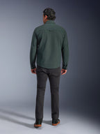 Alpinestars Bryon Water Resistant Overshirt in Dark Emerald, achteraanzicht op model, gecombineerd met een donkergrijze motorbroek en zwarte motorschoenen, klassiek op werkkleding geïnspireerd ontwerp met een iets langere achterkant voor verbeterde dekking tijdens het rijden.