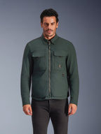 Alpinestars Bryon Water Resistant Overshirt, Dark Emerald, urban motorjas voor heren, mannelijk model draagt donkergroen overshirt met ritssluiting aan de voorzijde en grote cargozakken op de borst, waterbestendig gewaxt canvas voor motorrijden op de weg