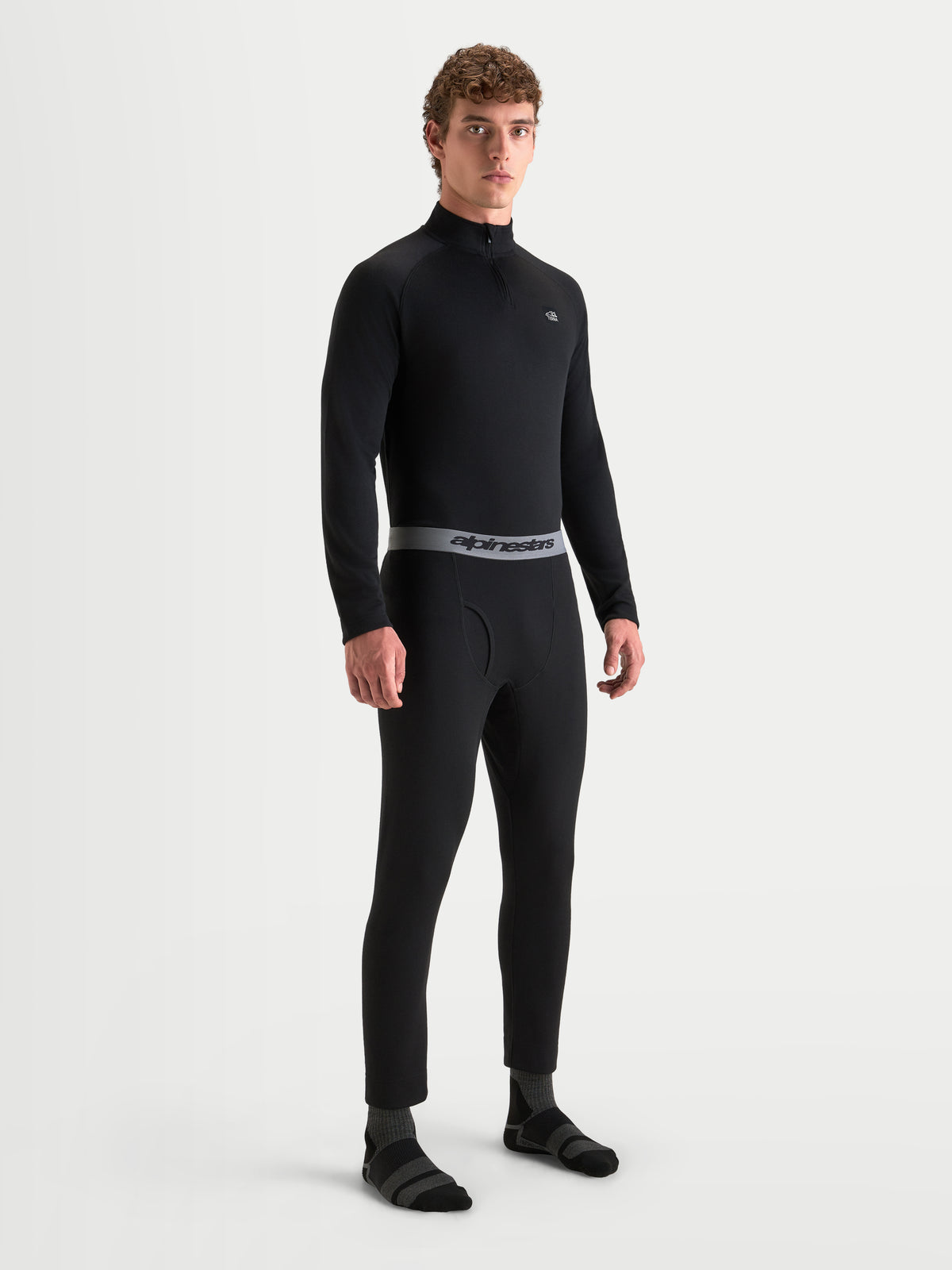 Alpinestars AT-8 Merino lange basislaag, heren motorondergoed, zwart met grijze tailleband van merinowol en polyester, gedragen door een model