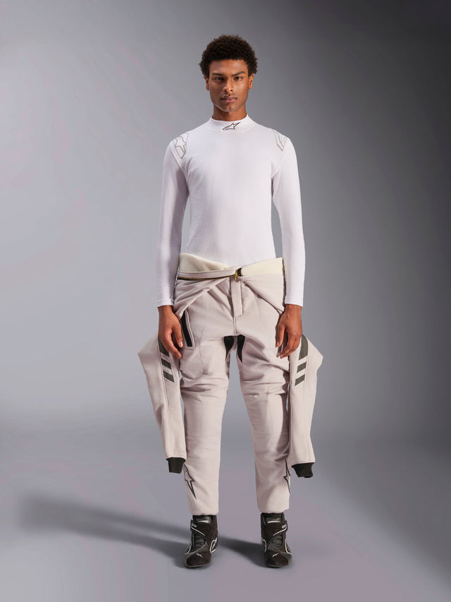 Alpinestars ZX Evo V3 Top, Long Sleeve, White, auto racing base layer worn with a light-colored racing suit tied around the waist and black racing boots, featuring a mock neck with logo and shoulder branding, professional flame-resistant motorsport underwear